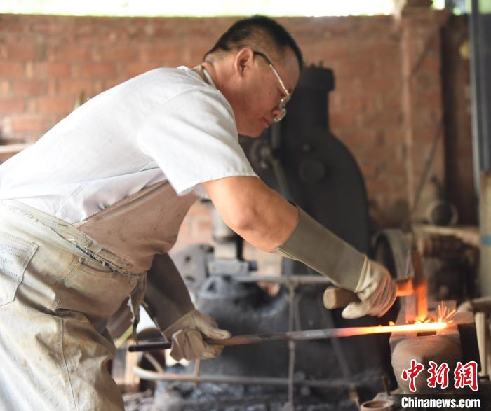 王二兵在對(duì)燒制的劍進(jìn)行鍛打。　高占峰 攝
