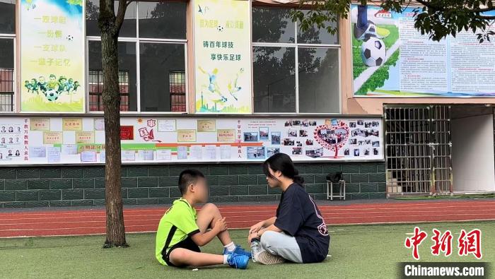 暑假期間，小嘉的姐姐帶他來踢球。原先小嘉不愛說話，踢球之后，更愿意跟家人溝通了?！￡愑裣?攝