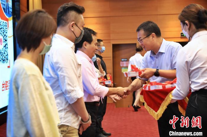 8月25日，北京市臺辦向臺胞代表贈送《臺胞百問》手冊?！±钛┓?攝