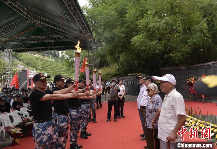 抗戰(zhàn)志士后人從百歲老兵手中引燃火炬，點亮長明火。　鐘欣 攝