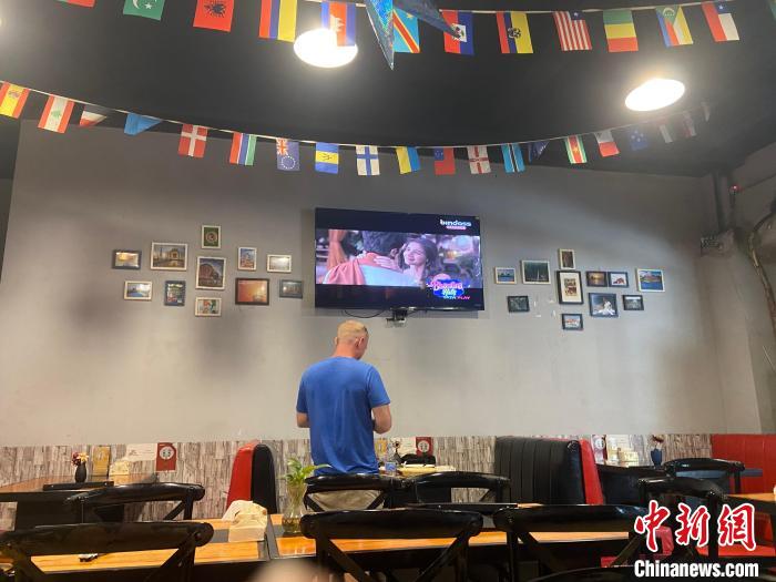 走進(jìn)店里，掛在天花板的各國(guó)國(guó)旗映入眼簾，電視中正播放著印度電影?！⒂駶?攝