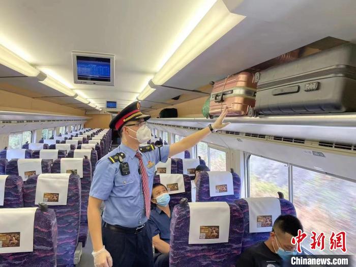 圖為9月5日，D1797列車上，工作人員為旅客整理行李架?！埼慕?攝