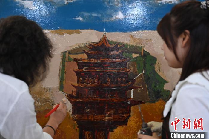 圖為劉志剛與學(xué)生進行敦煌元素漆畫創(chuàng)作。　李亞龍 攝