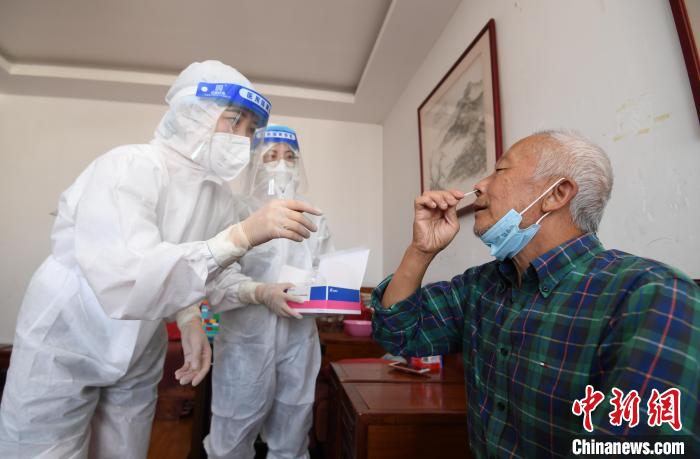 圖為貴陽市南明區(qū)望城街道的工作人員上門指導老年人進行抗原檢測?！≮w松 攝