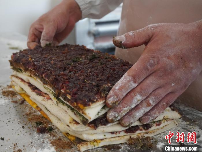 圖為將抹好餡料的月餅層層疊放?！钅?攝