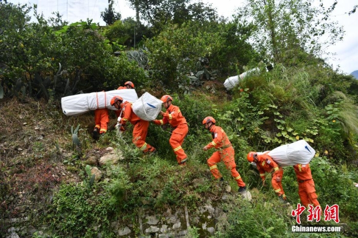資料圖：消防員徒步運(yùn)送帳篷物資。 張浪 攝