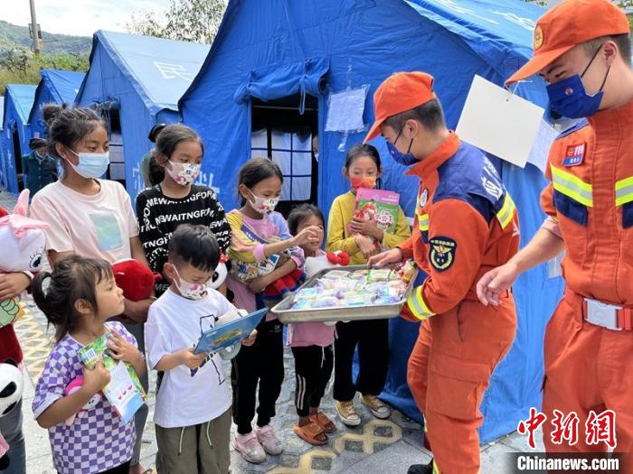 臨時(shí)安置點(diǎn)消防員給村民和孩子送上中秋月餅?！埼?攝