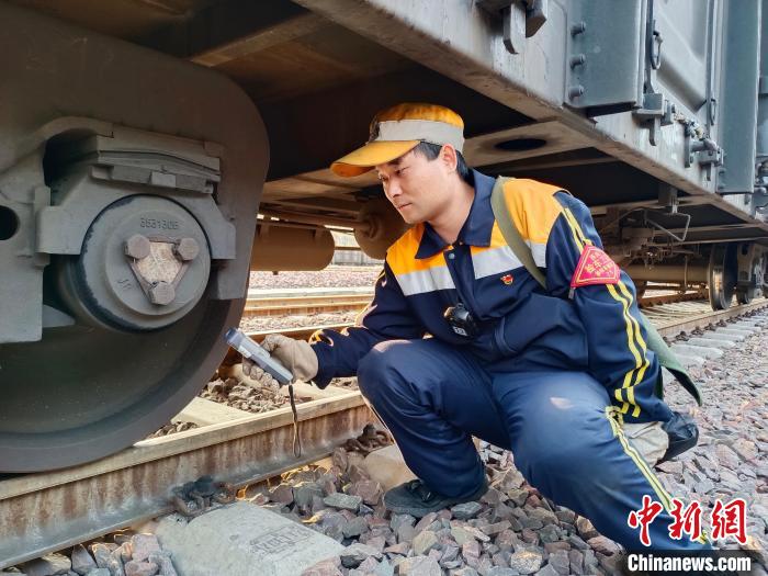 圖為張建亮在檢查車輛軸承溫度。　朱俊麟 攝