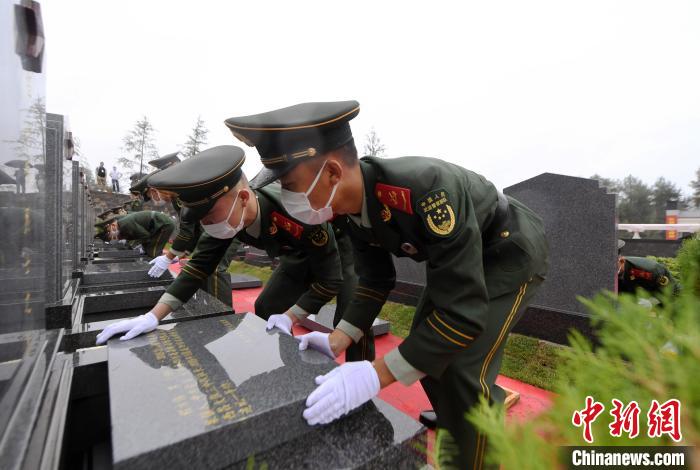 武警官兵將烈士遺骸送至墓位安葬。　郭傳伍 攝
