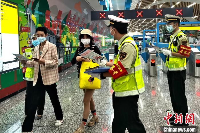 圖為交通執(zhí)法人員向出站旅客發(fā)放相關(guān)宣傳冊?！埿?攝