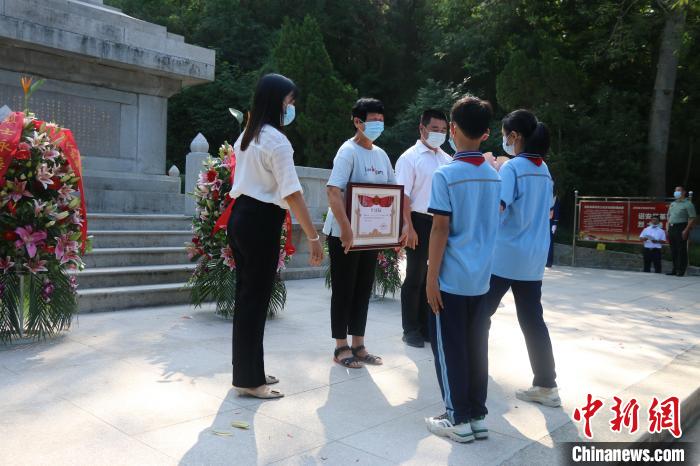 少先隊(duì)員向烈屬敬獻(xiàn)鮮花?！≌闹菔型艘圮娙耸聞?wù)局供圖