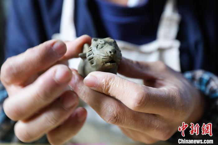 姚德波捏制的老虎形狀“桐梓泥哨”?！■暮陚?攝