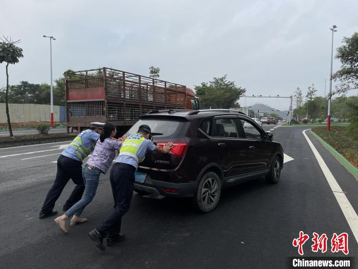佛山高明公安警輔人員協(xié)助司機(jī)將故障車(chē)輛推至安全區(qū)域。　伍皓然 攝