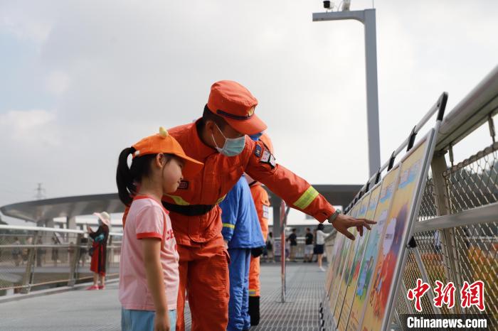 森林消防員正在防火宣傳展板前與小朋友進(jìn)行科普講解?！↑S山鴻 攝