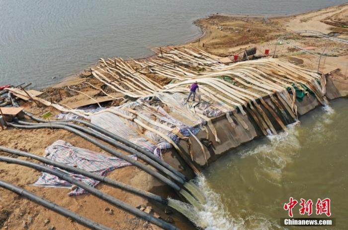 圖為在鄱陽(yáng)湖畔的江西省南昌市新建區(qū)昌邑鄉(xiāng)江邊電力排灌站，工作人員從外河引水渠抽水灌溉農(nóng)田。(資料圖) 劉占昆 　攝