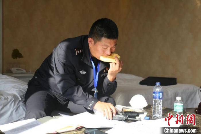 圖為李輝一邊吃飯一邊工作。　敖都布仁 攝