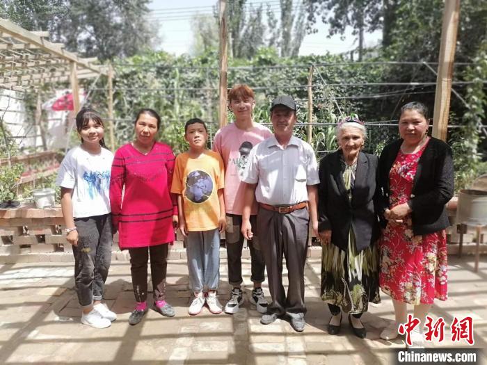 108歲老人努爾·依地?zé)崴?右二)喜愛勞作，澆花，喂羊，烤包子等都親力親為。圖為老人與部分子孫。　朱景朝 攝