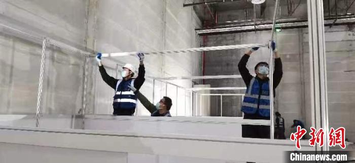 圖為工人搭建方艙醫(yī)院現(xiàn)場?！《毠﹫D