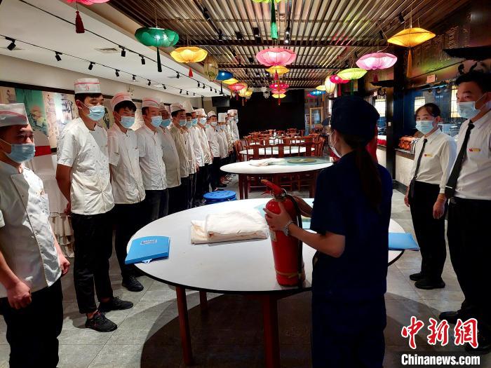 檢查期間，消防協(xié)管員為一家飯店后廚工作人員普及消防知識(shí)?！垘泿?攝