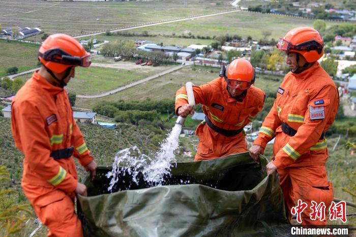 技能大練兵過(guò)程中，消防員在陡坡上向蓄水池注水?！±顕?guó)燾 攝