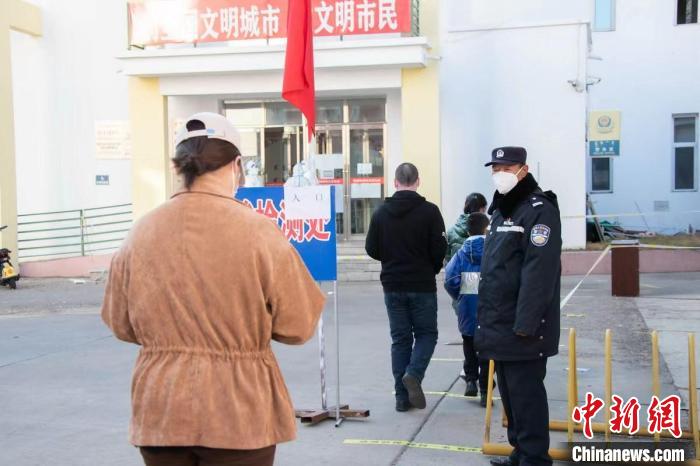 圖為王福在維持核酸檢測(cè)秩序。　石英 攝