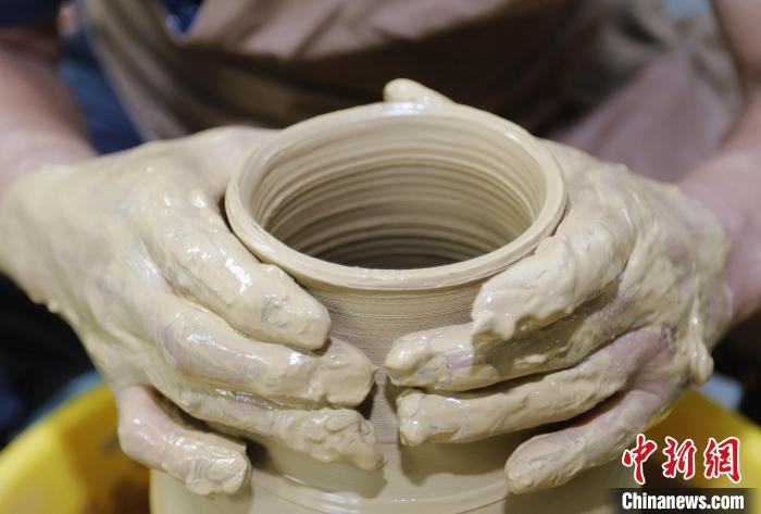 圖為張明正在進(jìn)行創(chuàng)意陶藝的定形工序。　門(mén)叢碩 攝