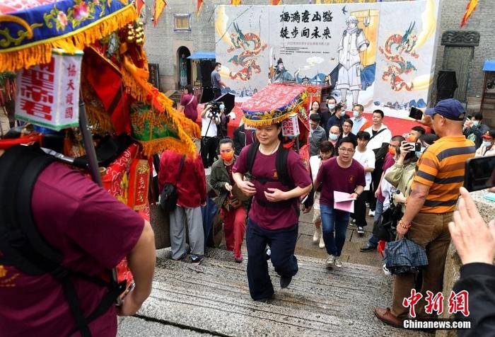 資料圖：5月12日，“福滿唐山路·徒步向未來(lái)”2022年兩岸青年信俗淵源尋根之旅活動(dòng)在福建福州啟幕，30多名閩臺(tái)青年恭請(qǐng)“福神”，背著端坐有關(guān)公、陳文龍神像的轎子從福州臺(tái)江區(qū)三通橋頭出發(fā)，開(kāi)啟一場(chǎng)祖脈尋根之旅。 <a target='_blank' href='/'>中新社</a>記者 呂明 攝