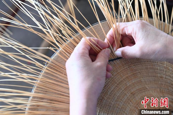 工匠正在編織花竹帽。　王以照 攝
