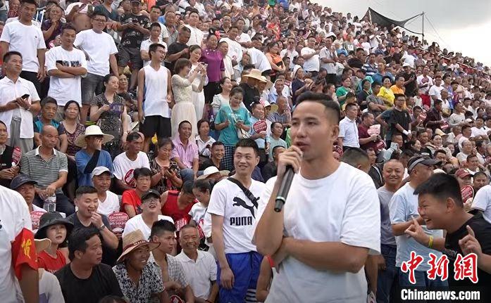 圖為臺盤村村民王再貴擔任球賽解說。　袁超 攝