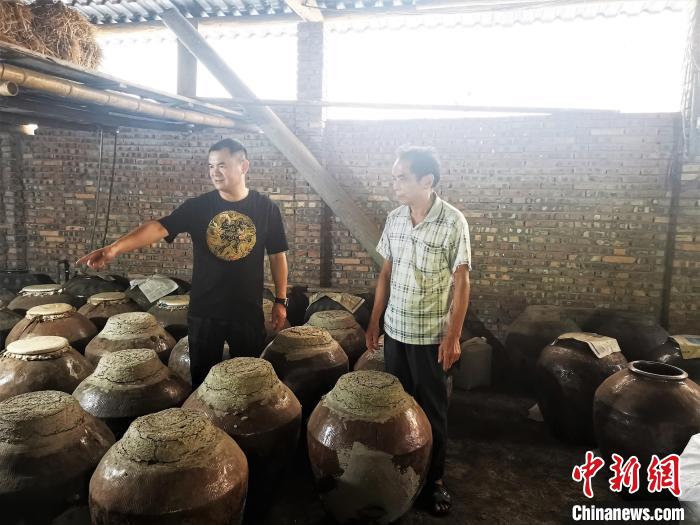 吳善遠(左一)上門向農戶收購黃酒?！∑聊峡h委組織部 供圖