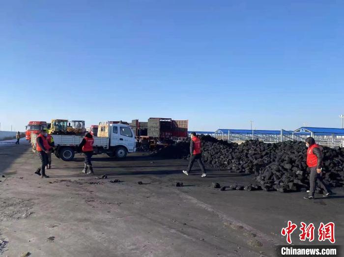 圖為工作人員正在協(xié)助牧民裝煤?！氁舳继m 攝