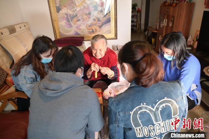 圖為周有玉在家中教授居民串珠手工藝品制作技藝?！￡愽?攝