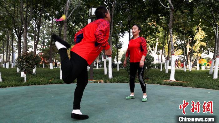 圖為白賀成(左一)和毽友在公園踢毽。　臧振清 攝