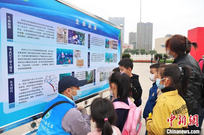圖為2022年度江西省古生物化石保護(hù)利用科普宣傳活動南昌分會場，志愿者在給幾位小朋友講解科普知識?！⒘?攝