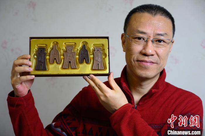山西平面廣告設計師孫晟展示他設計制作的布幣巧克力?！№f亮 攝