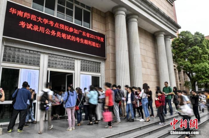 資料圖：華南師范大學(xué)考點(diǎn)，參加公務(wù)員考試的考生步入考場。<a target='_blank' href='/'>中新社</a>記者 陳驥旻 攝