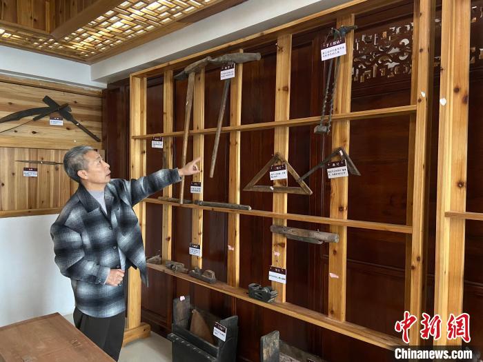 圖為葉偉平向前來參觀的民眾介紹修復(fù)古建筑時使用的工具。　劉玉潔 攝