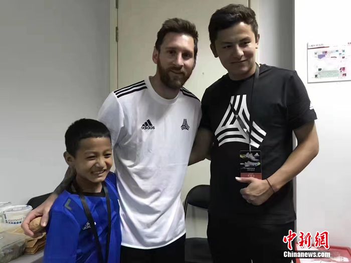 阿布都拉哈力克·艾木杜拉和他的體育老師在北京，與梅西合影。葉城縣教委供圖
