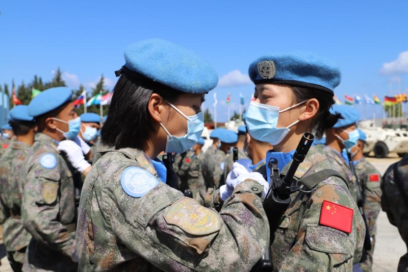 圖為2021年6月16日，在黎巴嫩南部辛尼亞村中國維和營舉行的授勛儀式上，接受檢閱的維和女兵進場前互相整理著裝。（新華社發(fā)）