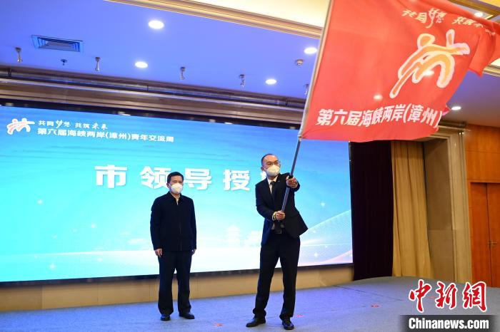 漳州市委副書記黃水木(左)為臺(tái)青代表曾冠穎授旗。　張金川 攝