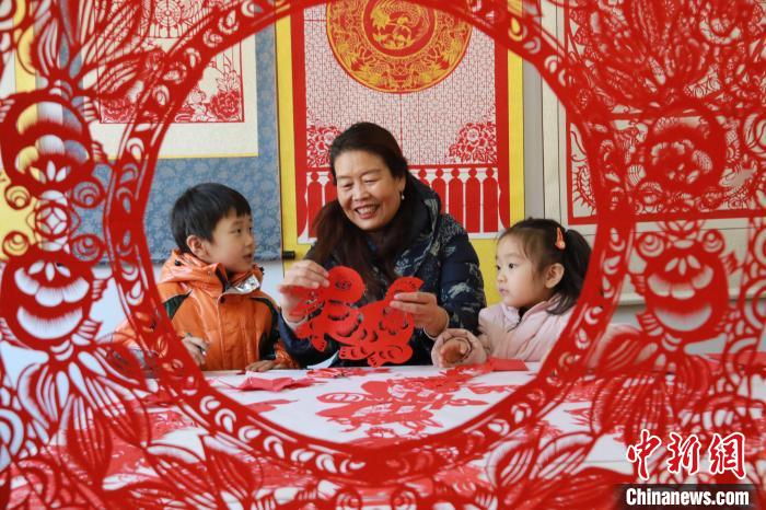 非遺傳承人田桂芹在帶領(lǐng)孩子們進(jìn)行迎新年剪紙創(chuàng)作?！±詈?攝
