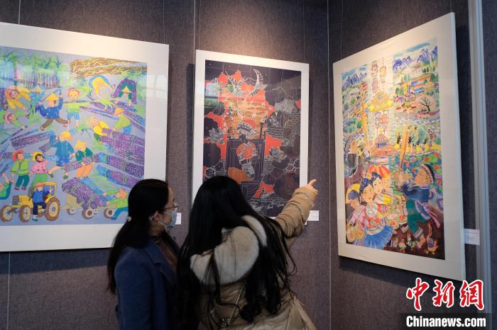 圖為前來(lái)觀展的民眾正在交流作品?！⒖÷?攝