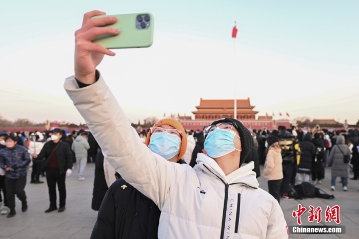 2023年1月1日晨，北京天安門廣場舉行隆重的升國旗儀式。人們來到天安門廣場觀看升旗儀式，迎接新年。圖為市民拍照留念。 <a target='_blank' href='/'>中新社</a>記者 趙文宇 攝