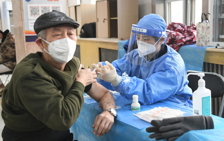2022年12月15日，在北京市海淀區(qū)中關村街道新冠疫苗接種點，醫(yī)護人員為老年人接種新冠疫苗。（圖源：新華社）