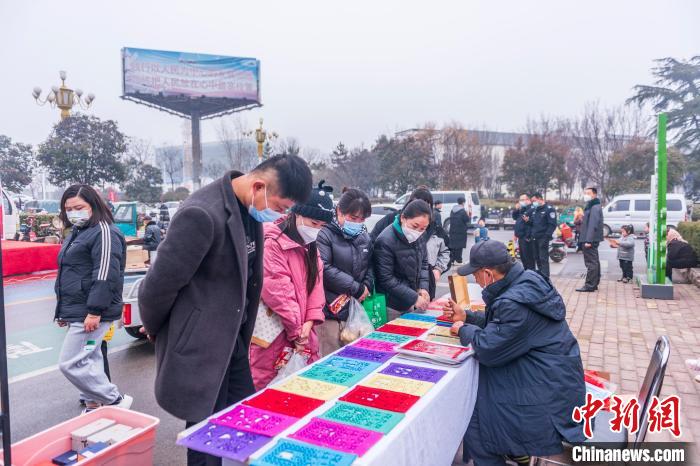 圖為村民在圍觀莒縣過(guò)門(mén)箋制作?！￡惞饨?攝
