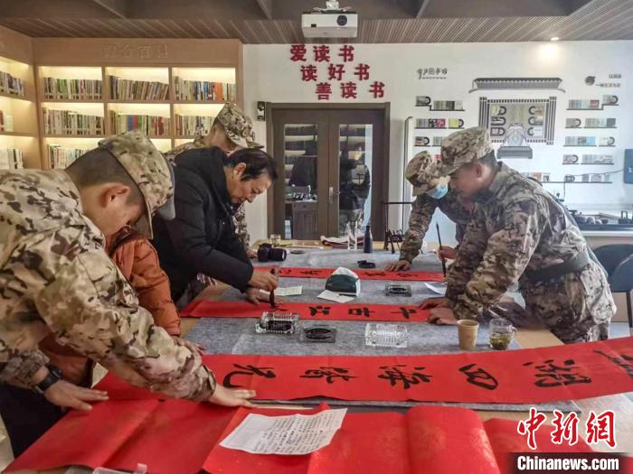 浙江衢州江山市離退休干部與武警衢州支隊江山中隊官兵共寫春聯(lián)?！”搴陮?攝