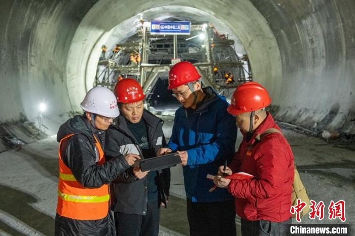 成蘭鐵路公司成蘭指揮部指揮長肖霞林(左二)與設(shè)計單位現(xiàn)場解決問題?！⒅铱?攝