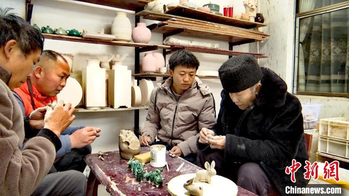 圖為張福高一家在捏制兔子?！『蚊髦?攝