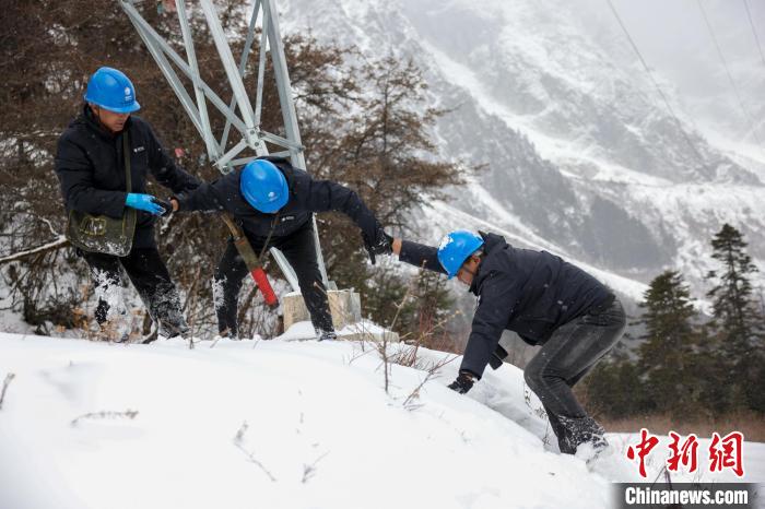 西藏波密縣電力巡護人員相互幫助，趟雪踏冰。　李東淮 攝