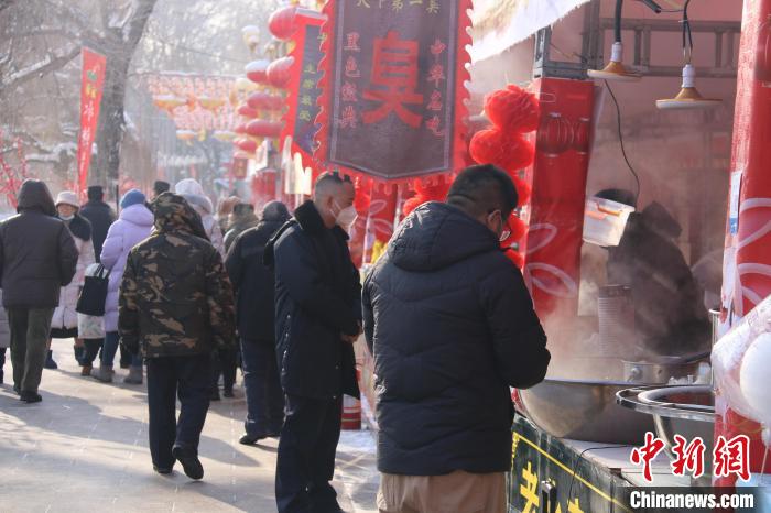 烏魯木齊市民在公園小吃攤上選購食品?！∨绥?攝